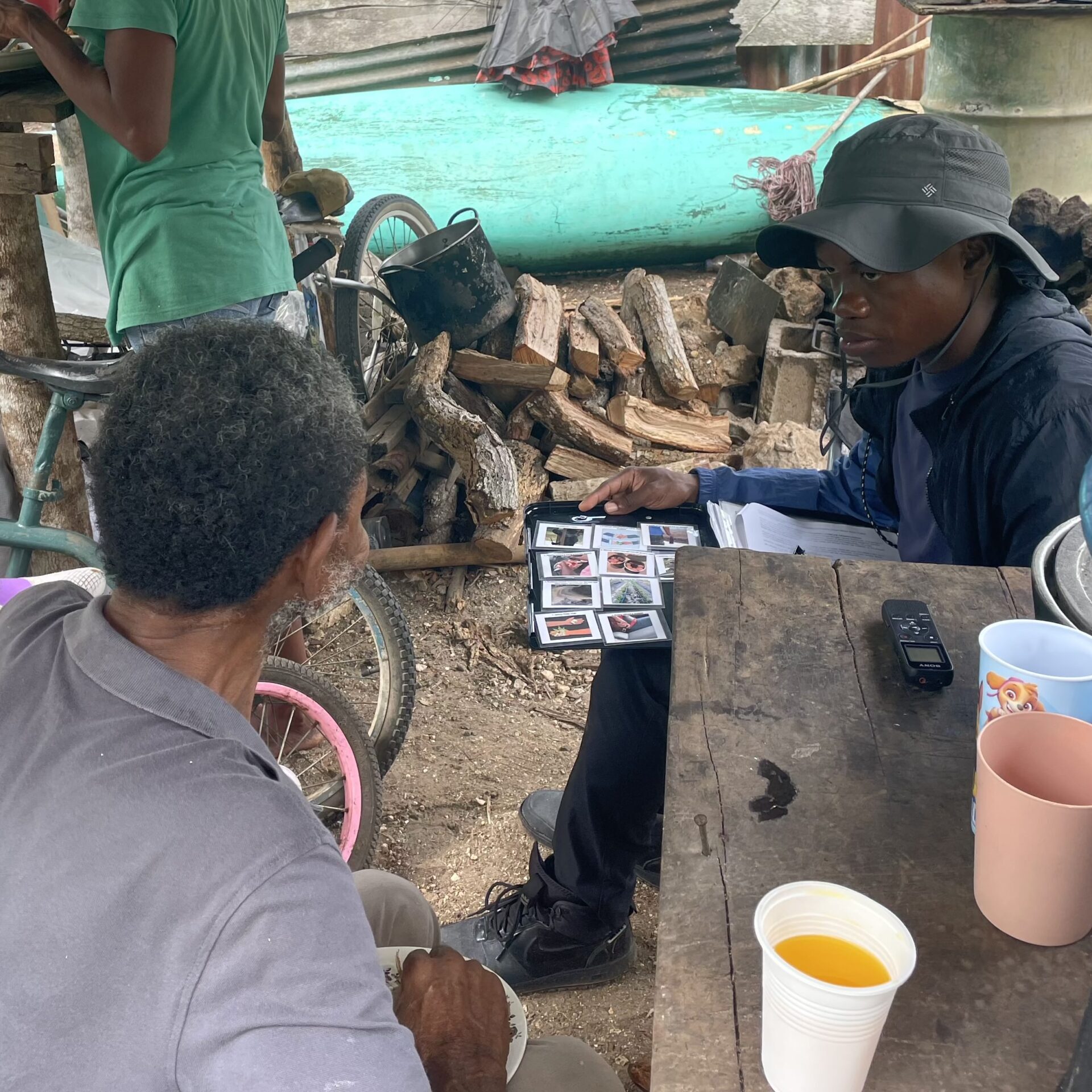 Semi-structured interview two men sitting outdoors at a wooden table having a conversation